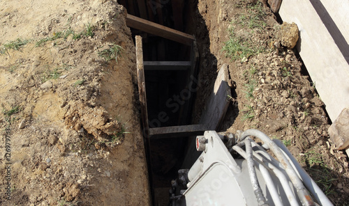 Excavator arm digging sewer row