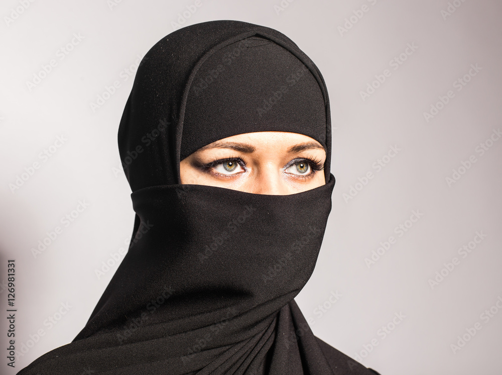 Naklejka premium Young woman wearing niqab on background