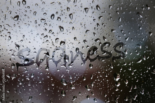 Sadness written on rainy window