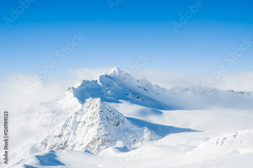 Snow-covered mountains and blue sky © smallredgirl