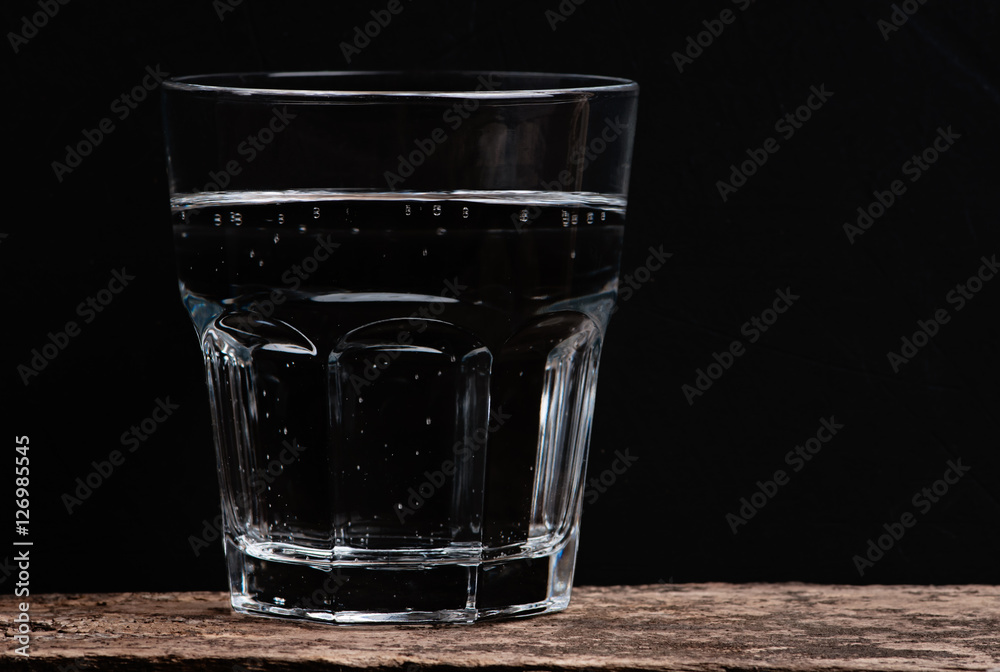 glass of clear water on the wooden textural background glass of clear water on the wooden textural background