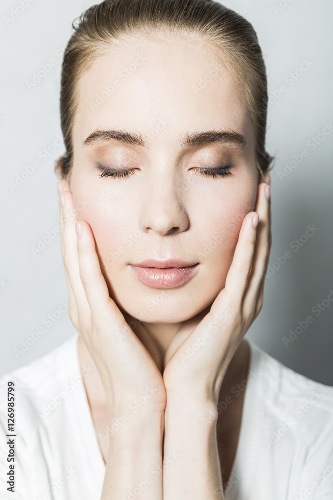 Portrait of young blonde beautiful girl with hands on face Portrait of young blonde beautiful girl with hands on face