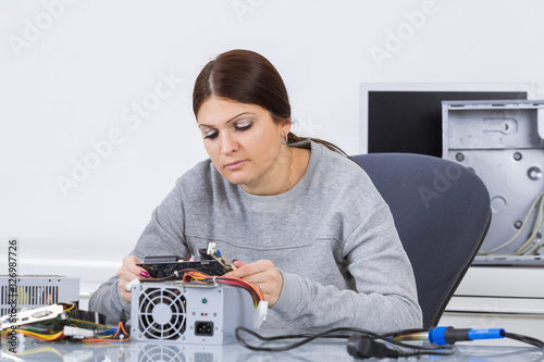 Woman examining computer component