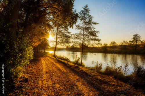 Landschaft im Herbst an einem Fluss bei Sonnenuntergang photo