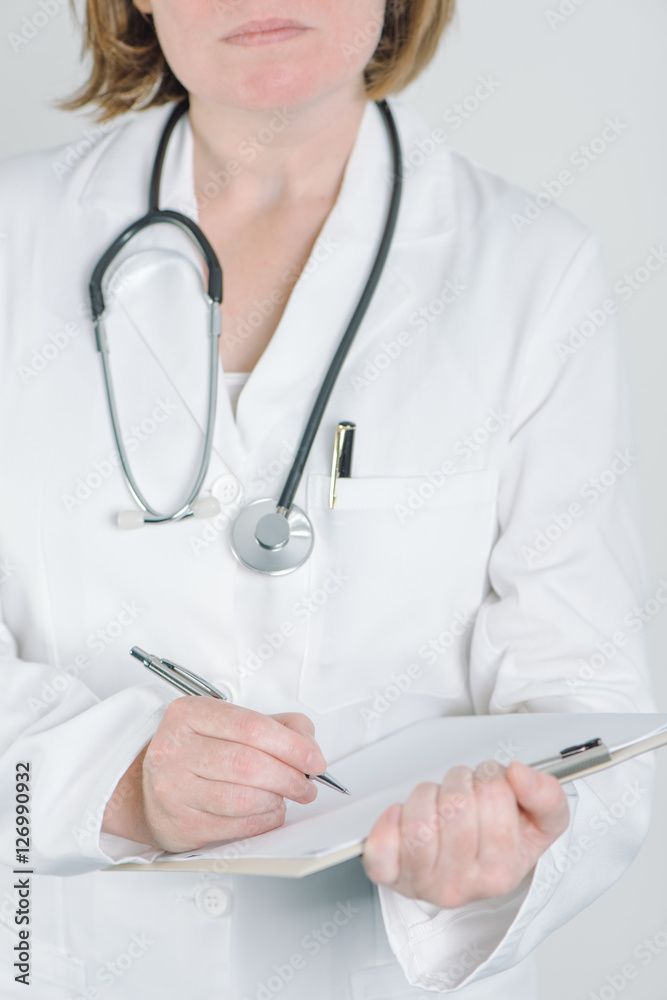 Female doctor writing on clipboard notepad blank paper Female doctor writing on clipboard notepad blank paper