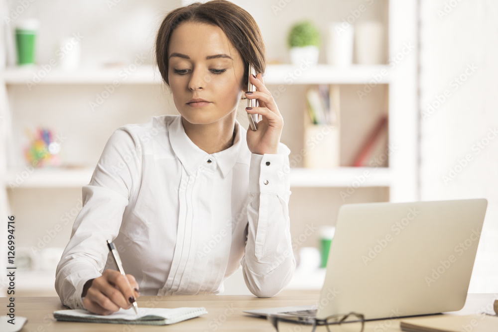 Female on phone doing paperwork Female on phone doing paperwork