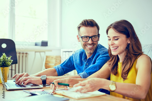 Photography Happy couple at home paying bills with laptop