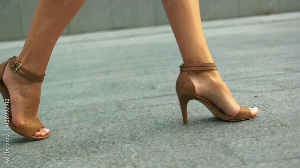 Close up of woman s legs walking outdoors in stylish summer shoes. Close up of woman s legs walking outdoors in stylish summer shoes.