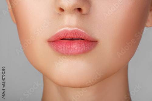 Perfect natural lip makeup. Close up macro photo with beautiful female mouth. Plump full lips. Close-up face detail. Perfect clean skin, light fresh lip make-up. Beautiful spa tender lip