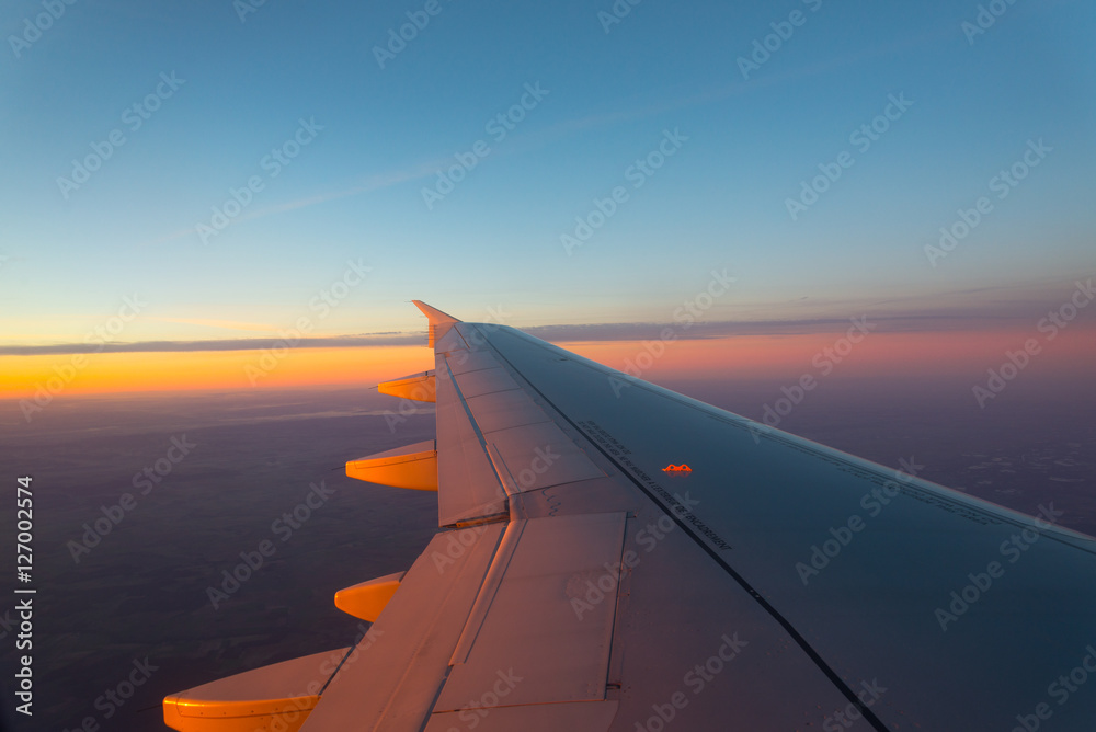 Airplane's window shot during the sunrise and cloudy sky