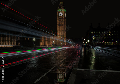 Reflection of Big Ben in puddle with light trails across Westminster Bridge, London, UK.