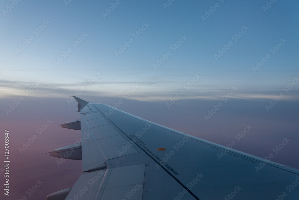 Airplane's window shot during the sunrise and cloudy sky