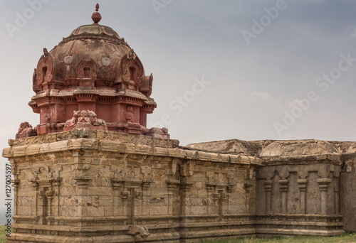 Dindigul, India - October 23, 2013: Closeup of Wing with Vimanam of the abandoned ruinous Shiva Temple on the Rock in Dindigul. Red painted dome on top of brown-beige sandstone.