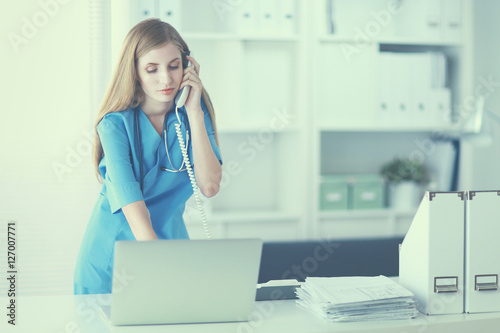 Female doctor talking on phone in diagnostic center photo