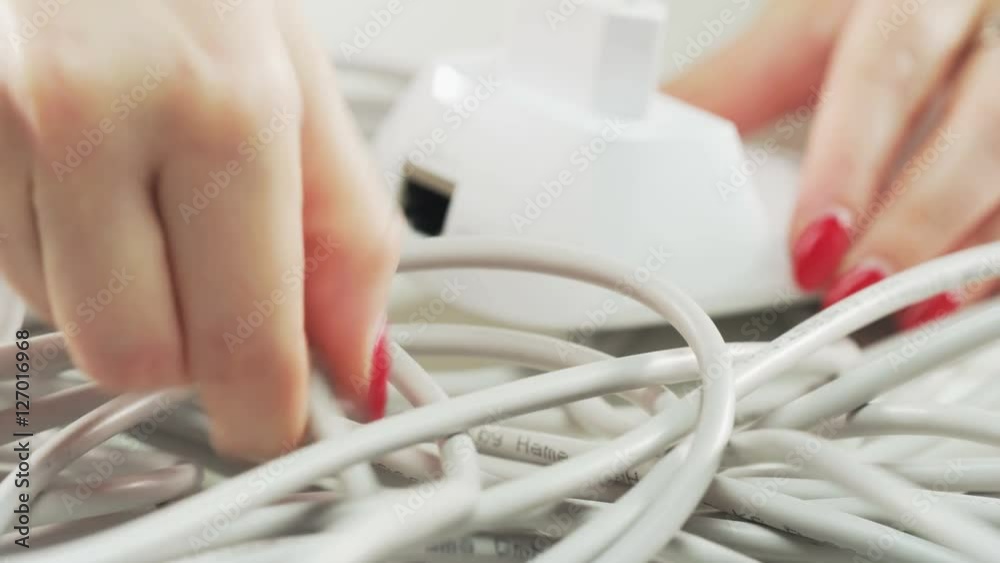 Woman Plugging a White Cable Woman Plugging a White Cable