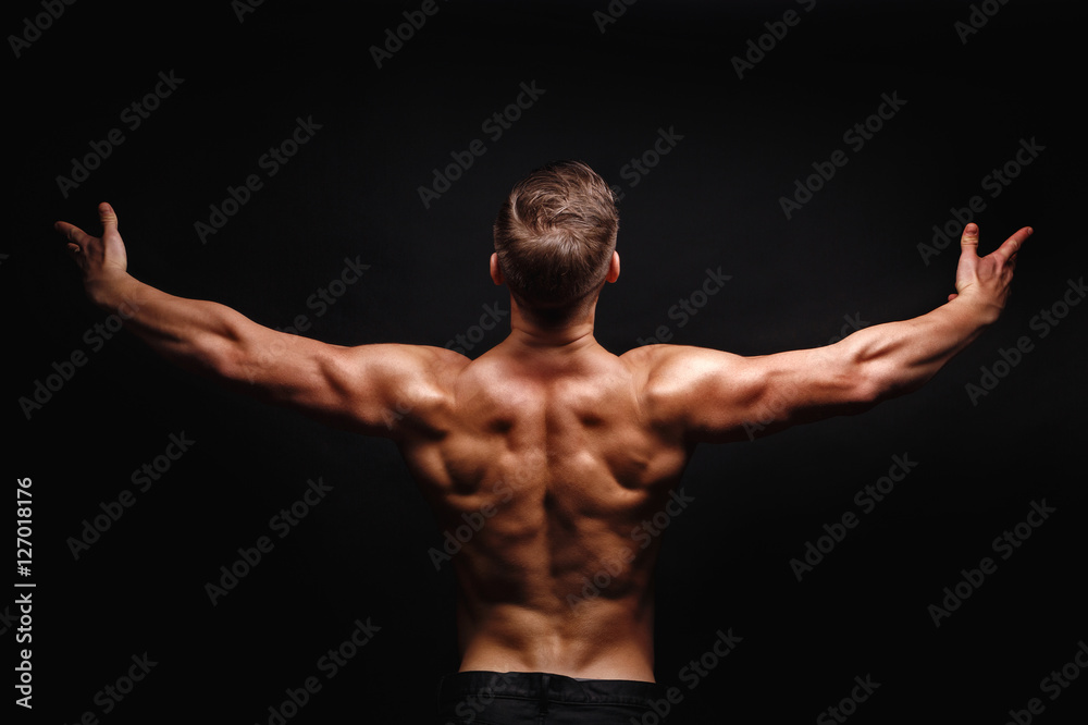 Bodybuilder Posing. Muscles the shoulders and back.