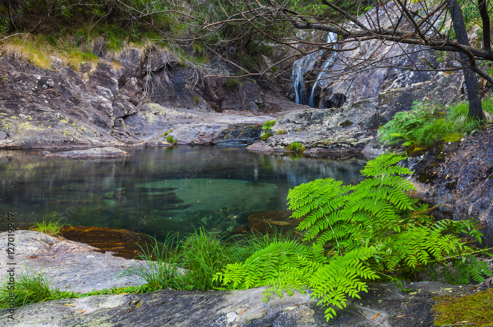 waterfall and lake in the middle of mountain surrounded by gree vegetation waterfall and lake in the middle of mountain surrounded by gree vegetation