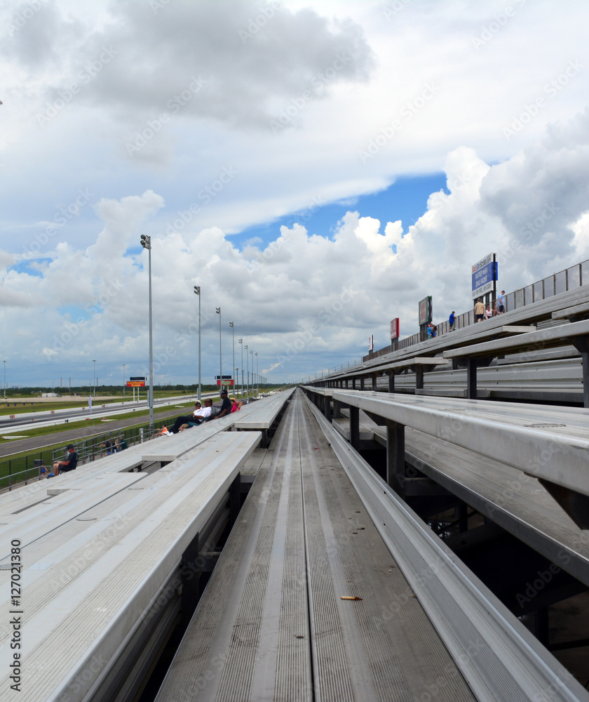 Bleachers/Long set of metal bleachers backed by cloudy sky