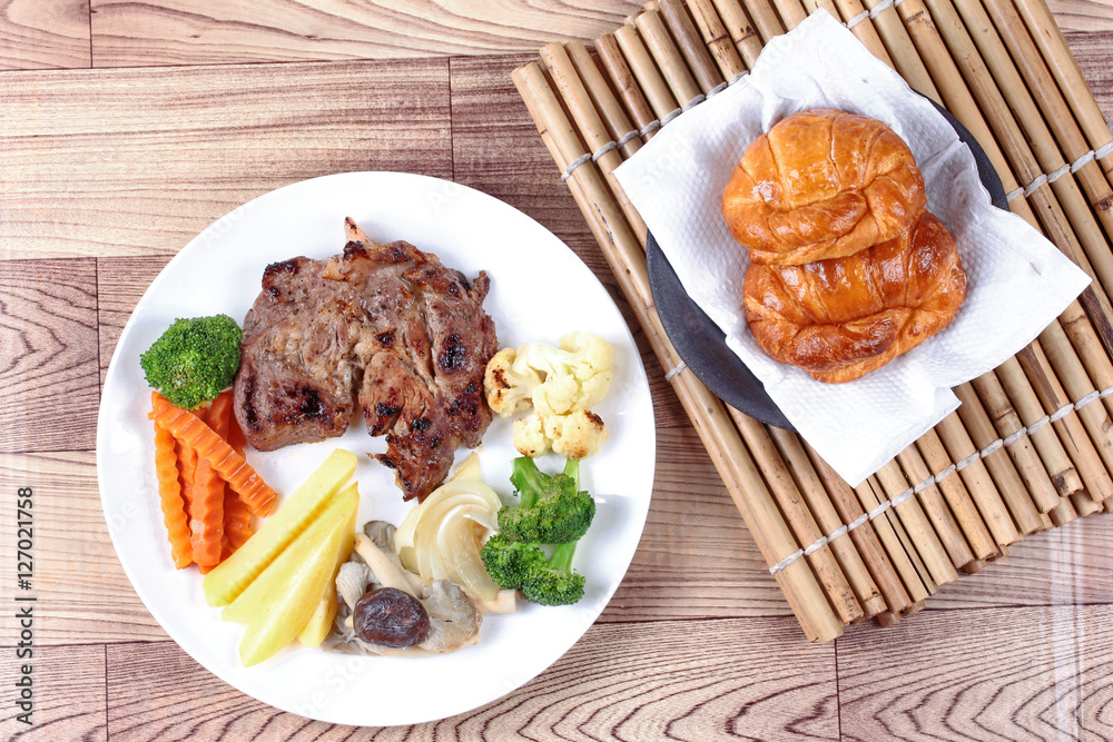 Home made ,Pork steak and mixed vegetables with croissants . Home made ,Pork steak and mixed vegetables with croissants .