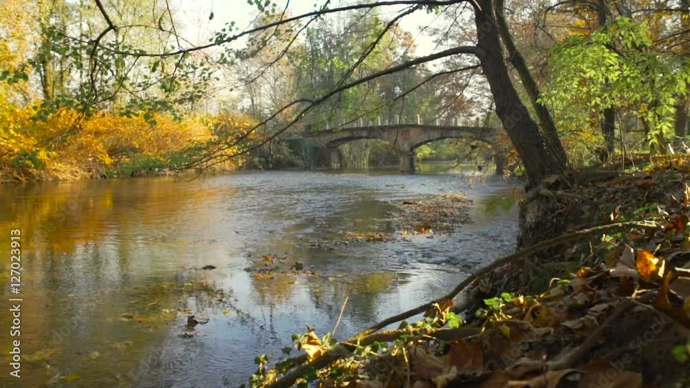 Old bridge on a quiet river and trees in autumn Old bridge on a quiet river and trees in autumn