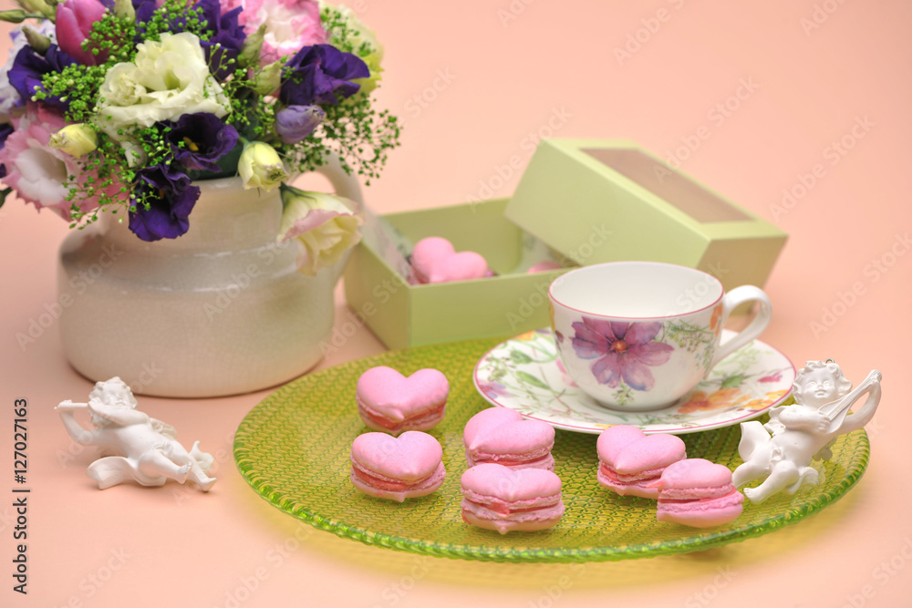 pink cookies in the shape of hearts on a plate with angels and flowers on Valentine's Day pink cookies in the shape of hearts on a plate with angels and flowers on Valentine's Day