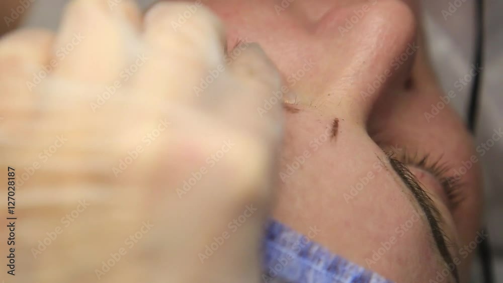 Cosmetologist applying permanent make-up. Old beautiful woman having cosmetic tattoo on her eyebrow. Beauty salon for women. Cosmetic tattoo. Cosmetologist applying permanent make-up. Old beautiful woman having cosmetic tattoo on her eyebrow. Beauty salon for women. Cosmetic tattoo.