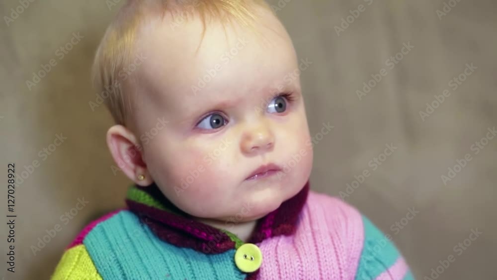 Baby girl eating from a spoon baby food, which gives him the mother Baby girl eating from a spoon baby food, which gives him the mother