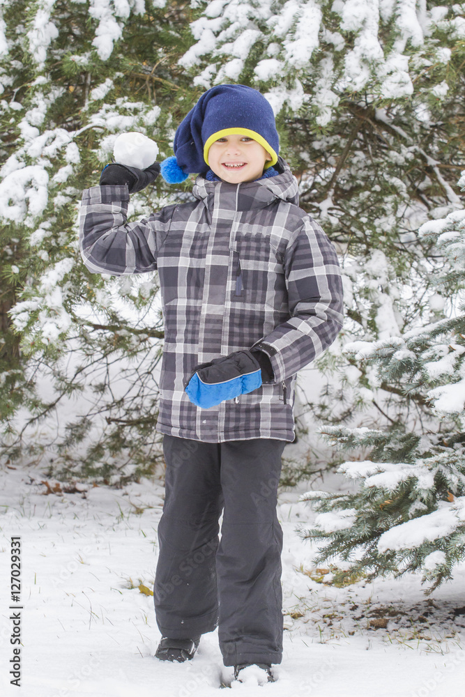 Boy throw snowball. Wintertime fun