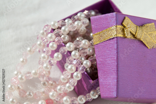 Ajar purple box with pink pearl strings   photo