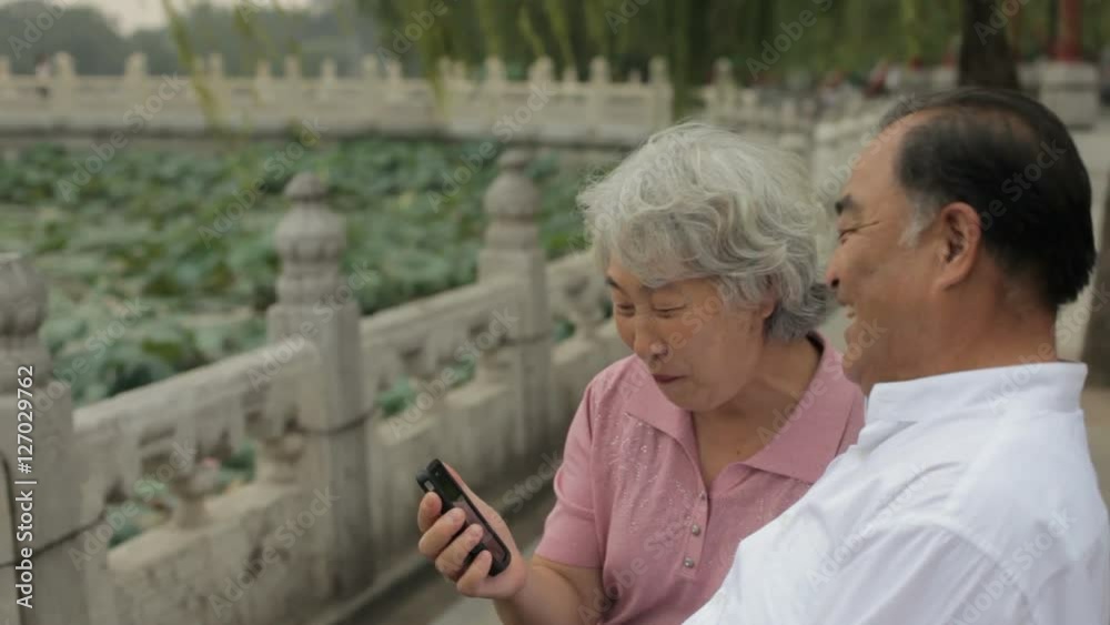 MS HA Elderly couple talking on mobile phone in a park/ Beijing, China MS HA Elderly couple talking on mobile phone in a park/ Beijing, China