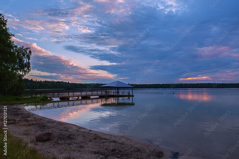 Wooded bridge in the lake between sunrise.