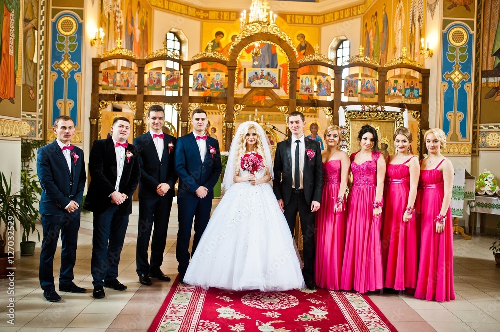 Stylish groomsmen and bridesmaids  with wedding couple at the church