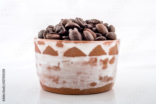 Roasted coffee beans in brown and white ceramic bowl..