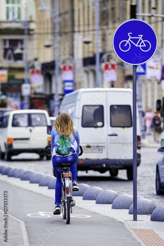 Young woman ride bicycle on bicycle lane. Bicycle lane sign. Bicycle. Pedestrian.
