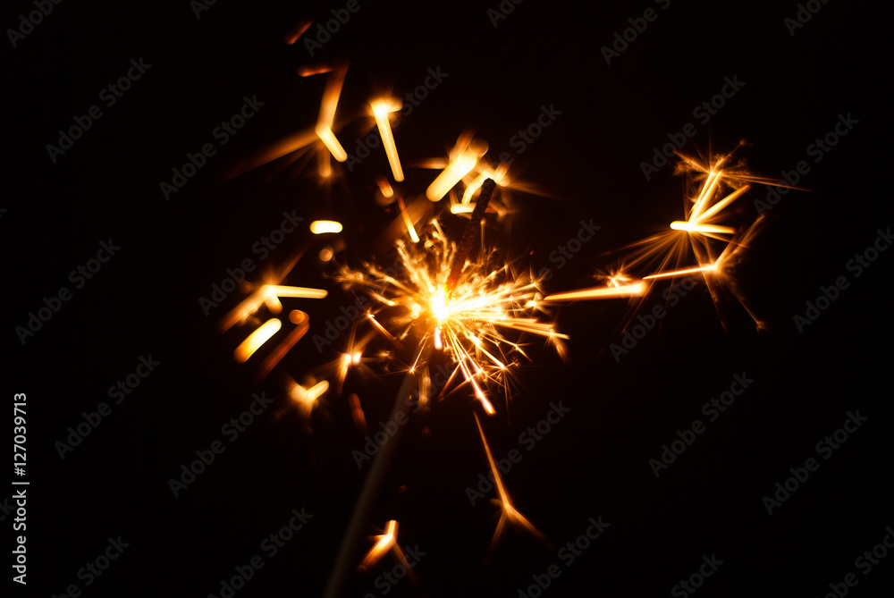 Sparkler on a black background, sparks fly in different directions, Sparkler on a black background, sparks fly in different directions,