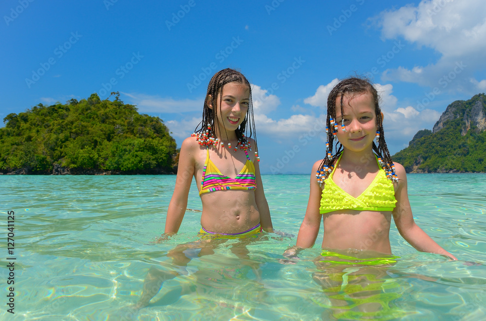 Obraz premium Happy children having fun in sea near tropical island, kids on beach vacation 