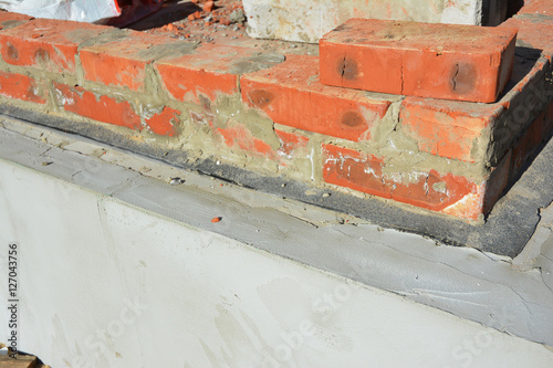 Damp proof membrane on top of foundation walls.