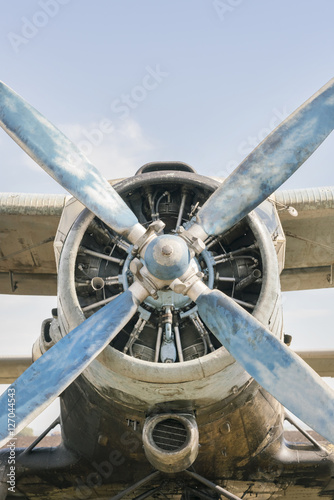 Part of a small blue and white plane on a background of blue sky
