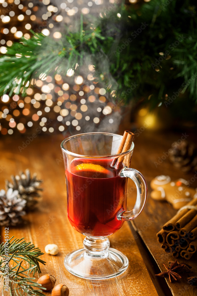 Mulled wine with citrus fruits and cinnamon on a table. Traditional winter hot drink for Christmas Eve party. Mulled wine with citrus fruits and cinnamon on a table. Traditional winter hot drink for Christmas Eve party.
