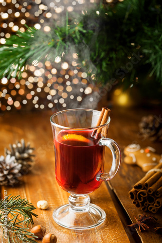 Mulled wine with citrus fruits and cinnamon on a table. Traditional winter hot drink for Christmas Eve party.