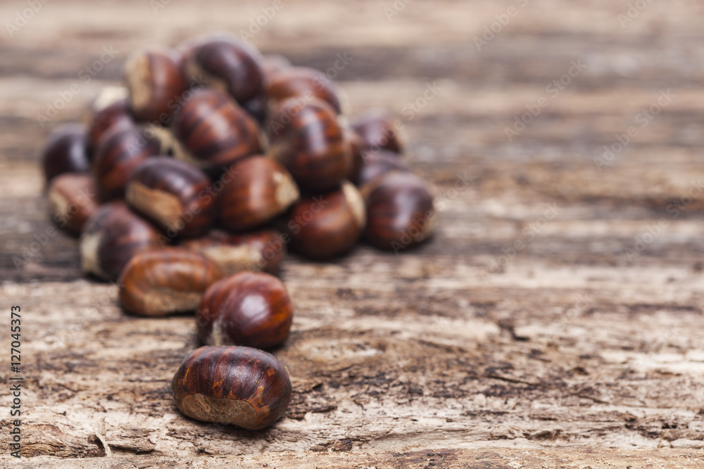 Raw chestnuts on wooden background Raw chestnuts on wooden background