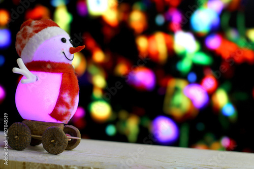 Christmas and New Year`s sale background with snowmen slides down on holiday bokeh lights. Foreground ready for product montage.Concept market banner, advertising poster with copyspace.