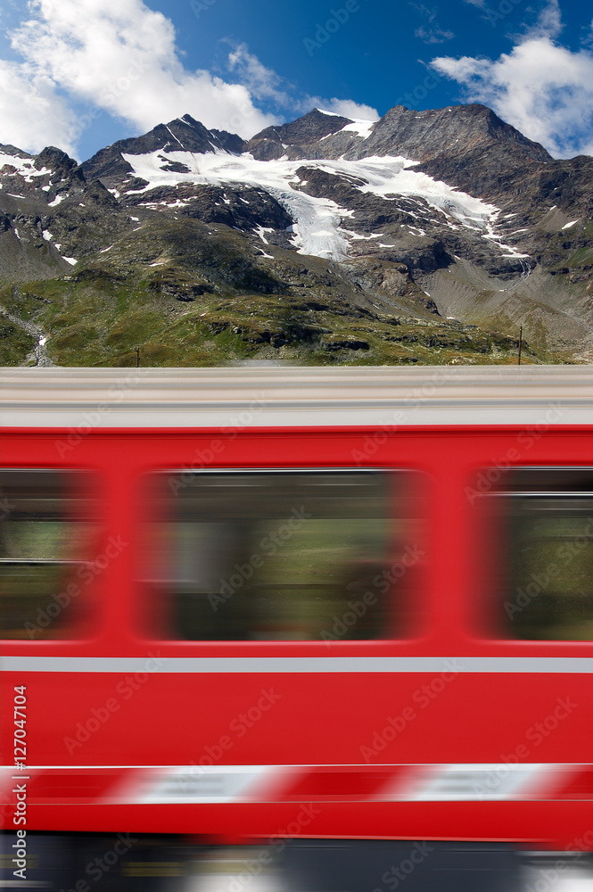 Fototapeta premium Red train in motion and the Bernina Alps, Engadine, Switzerland, Europe