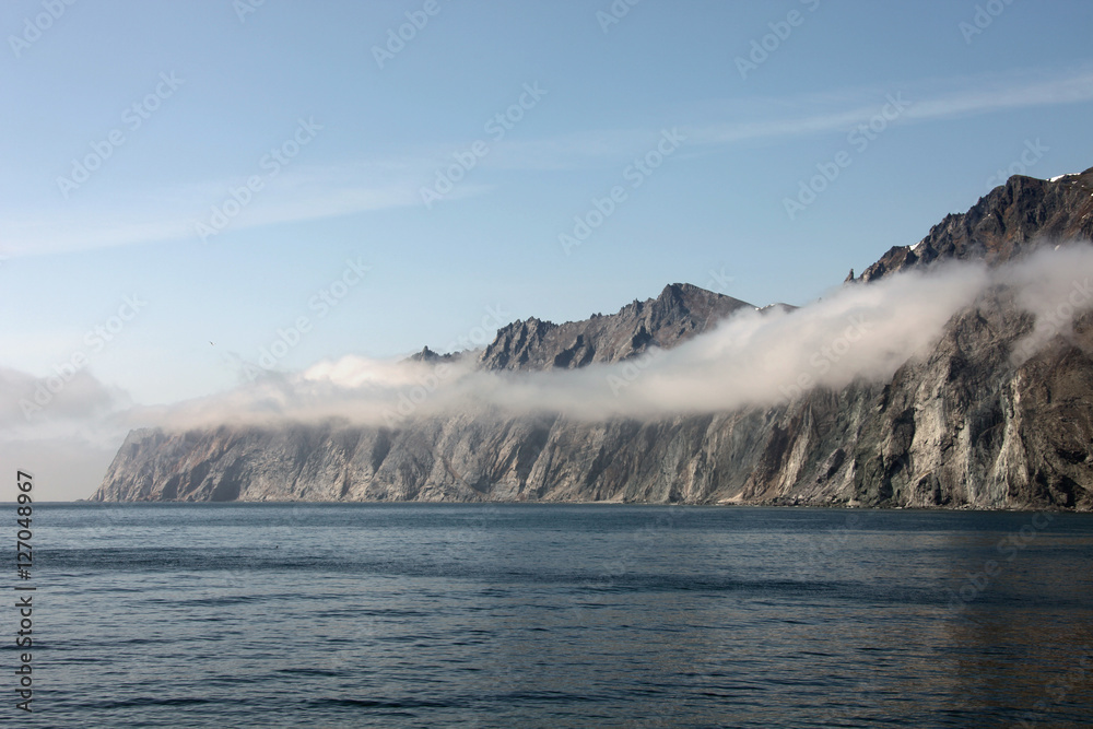 Rocky shore of the Okhotsk sea in the morning mist.