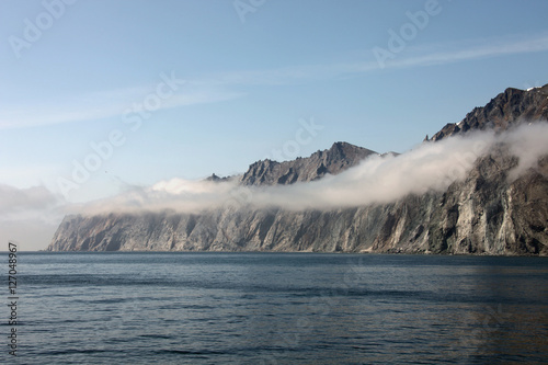 Rocky shore of the Okhotsk sea in the morning mist.