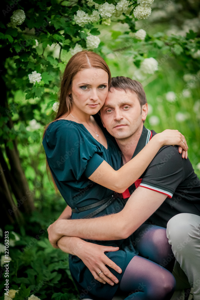 Dating. Young woman and man walking, couple in love relaxing in blossoming trees park at sunny spring day Dating. Young woman and man walking, couple in love relaxing in blossoming trees park at sunny spring day
