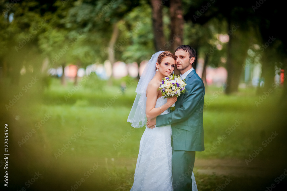 Elegant bride and groom posing together outdoors on a wedding day Elegant bride and groom posing together outdoors on a wedding day