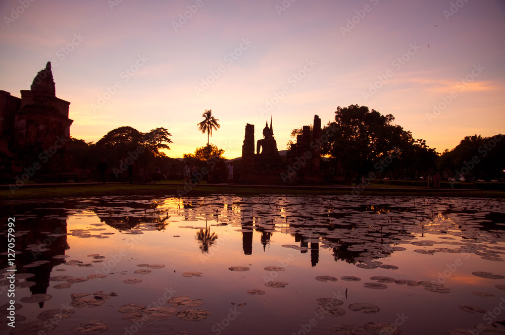Obraz premium Buddha and pagoda silhouette sky at Sukhothai History park, Sukhothai province, Thailand