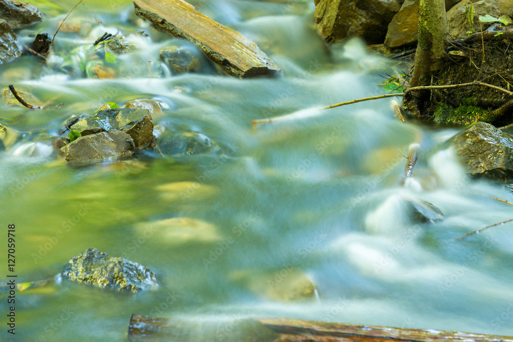 The movement of water in a forest stream shot with long exposure The movement of water in a forest stream shot with long exposure