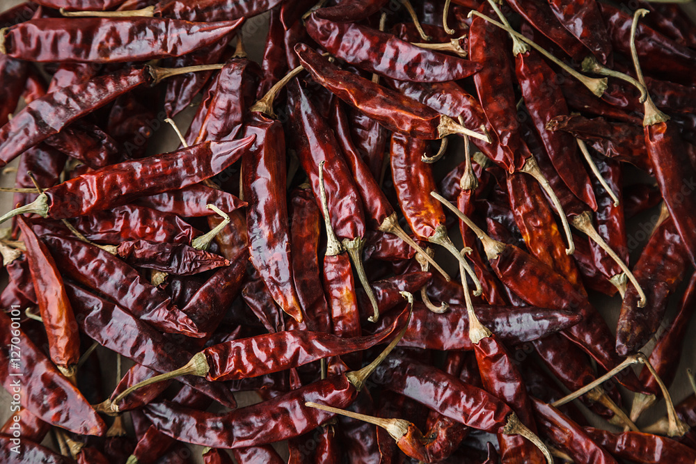Dried red hot chilli peppers on craft paper background.